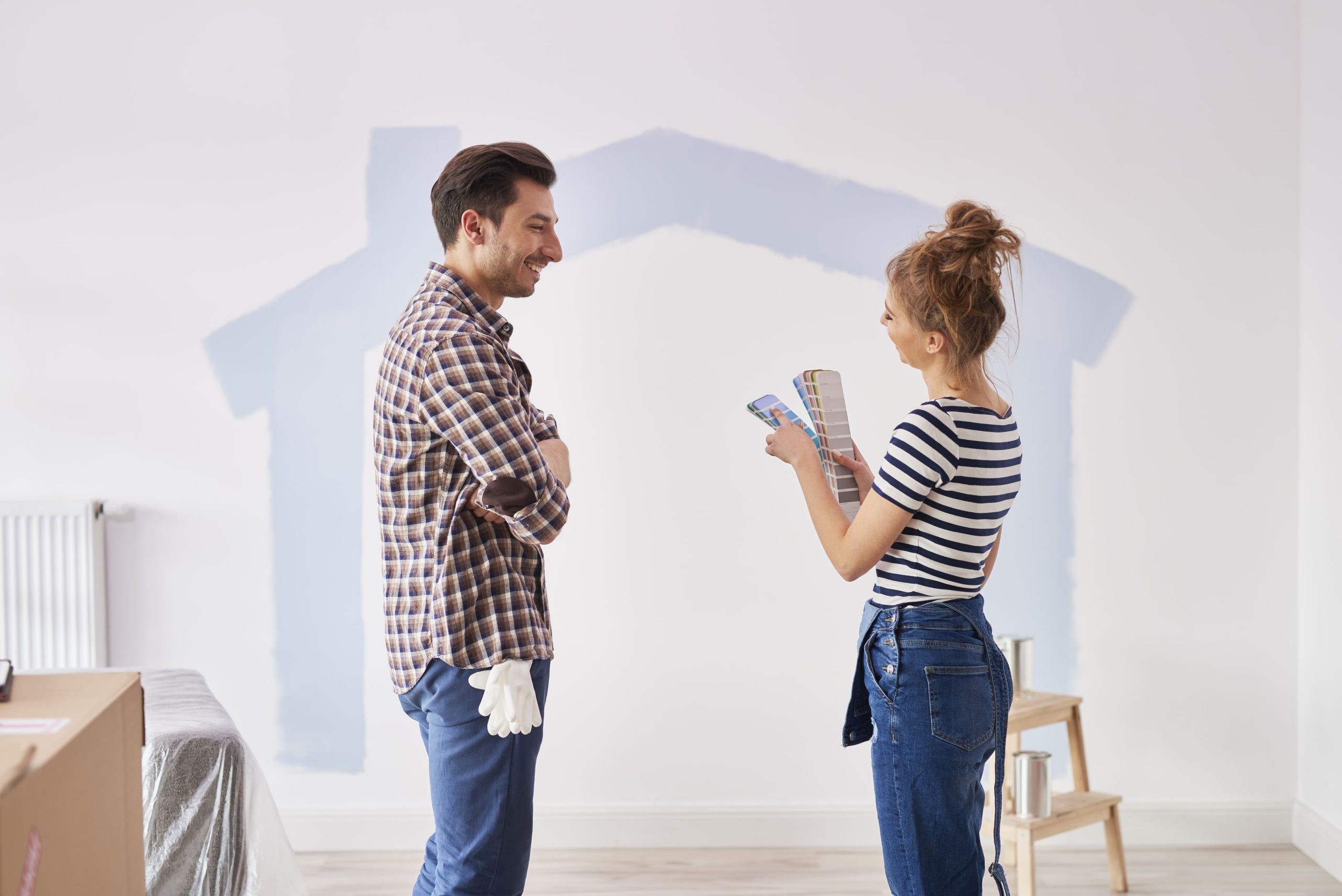 couple-painting-interior-wall-their-new-apartment